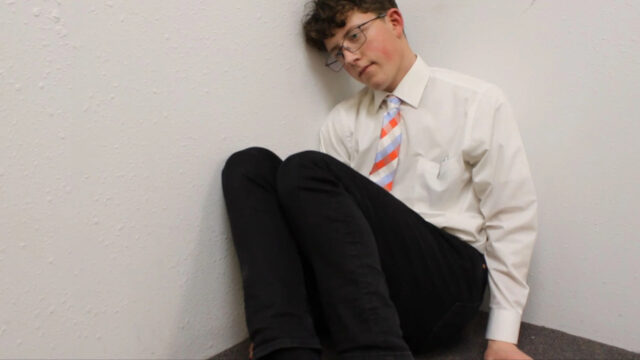 Young Man Sitting in Corner Desktop Wallpaper