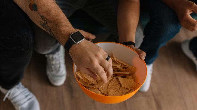 Friends Sharing Tortilla Chips at a Home Gathering Desktop Wallpaper