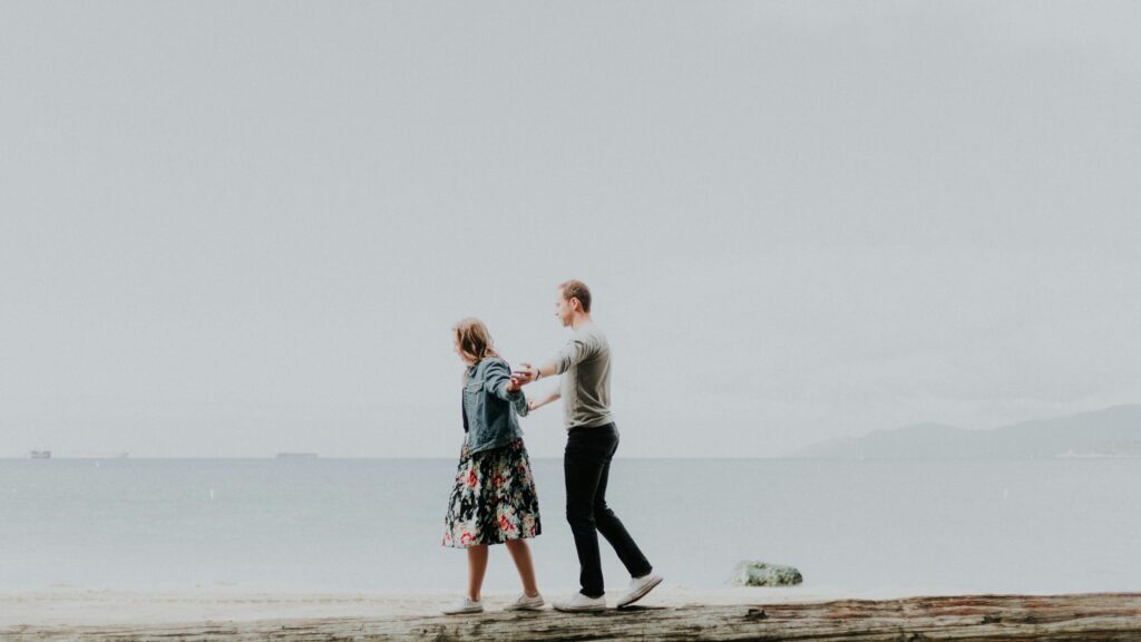 Romantic Couple Walking on Beach Log 4K Desktop Wallpaper