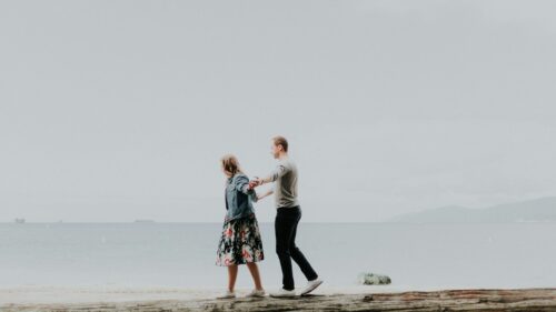 Romantic Couple Walking on Beach Log 4K Desktop Wallpaper