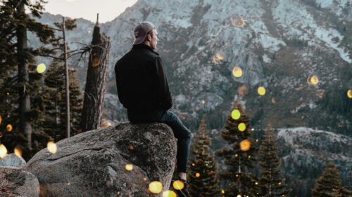Man Sitting on Rock Overlooking Mountain Landscape Desktop Wallpaper