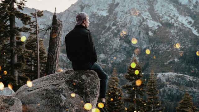 Man Sitting on Rock Overlooking Mountain Landscape Desktop Wallpaper