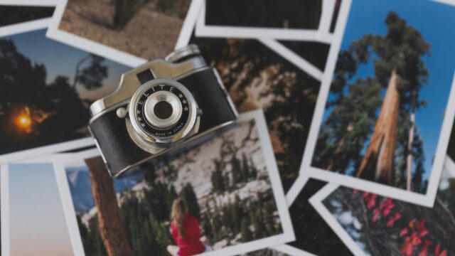 Vintage Film Camera on Stack of Nature Photos Desktop Wallpaper