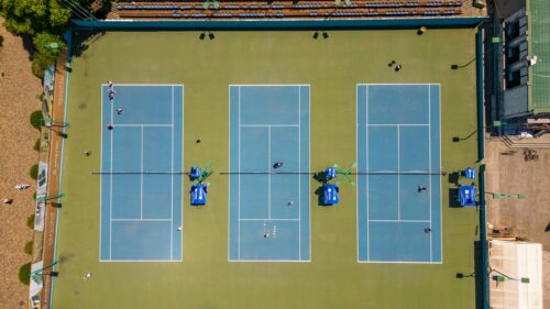 Aerial View of Tennis Courts with Blue Playing Surfaces 4K Wallpaper