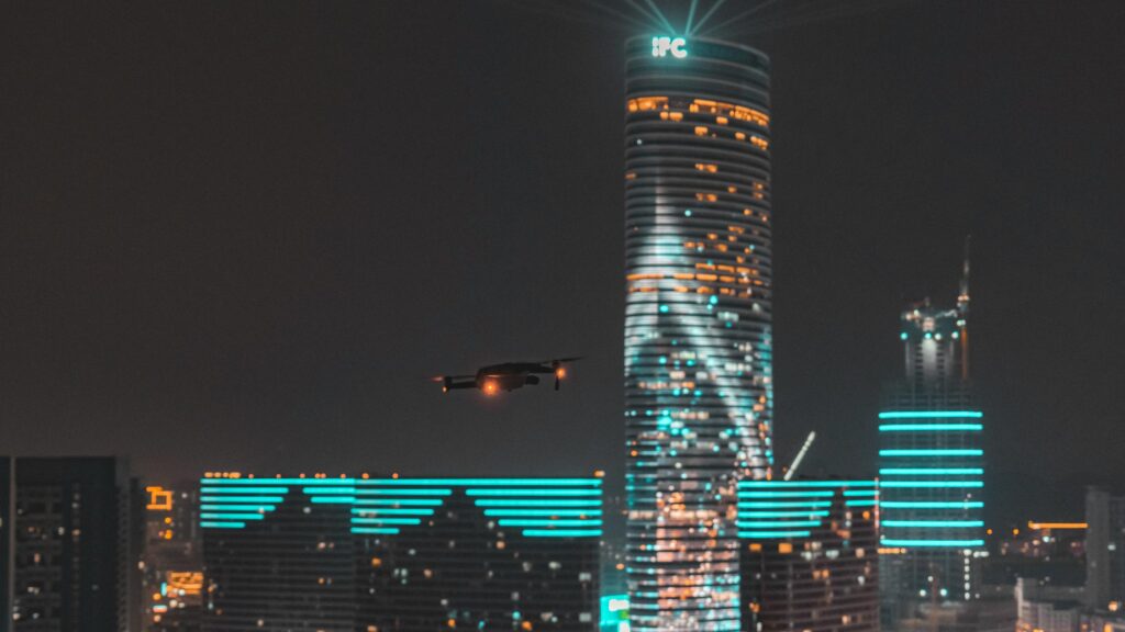Drone Flying Near Glowing IFC Skyscraper Night Cityscape 4K Wallpaper
