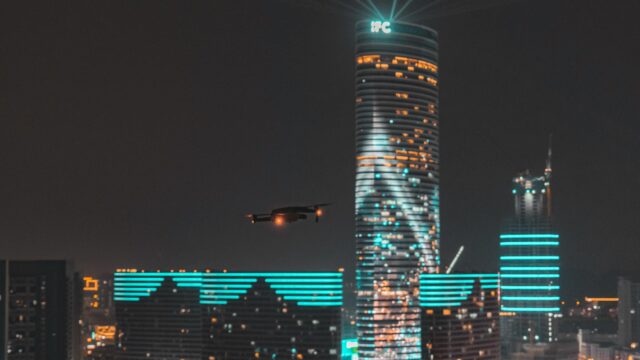 Drone Flying Near Glowing IFC Skyscraper Night Cityscape 4K Wallpaper