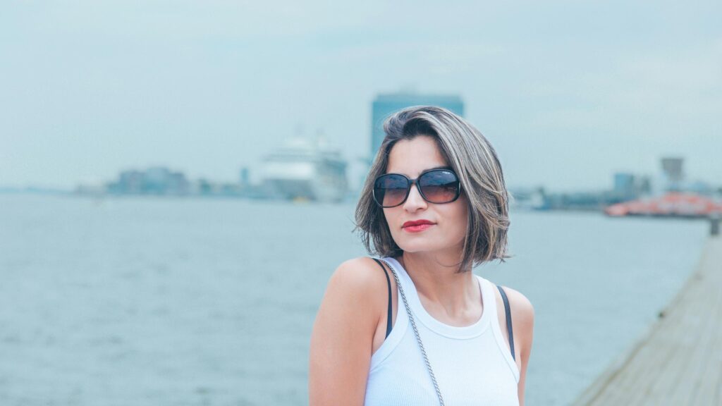 Woman with Sunglasses by the Harbor at Sea 4K Desktop Wallpaper