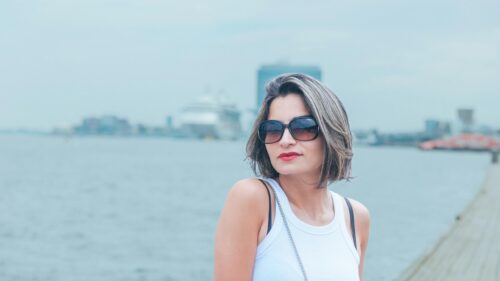 Woman with Sunglasses by the Harbor at Sea 4K Desktop Wallpaper