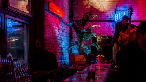 Neon Bar Nightlife Atmosphere with Double Bass Player 4K Wallpaper