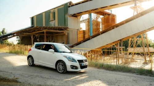 White Suzuki Swift Sport at Industrial Gravel Plant Desktop Wallpaper