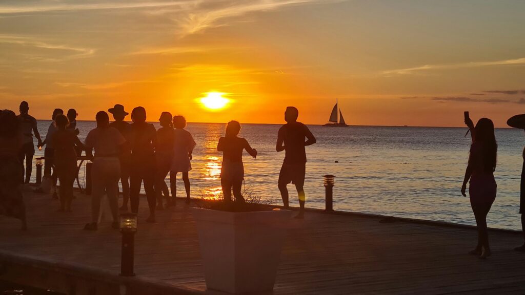People Silhouettes on Pier at Tropical Sunset Desktop Wallpaper