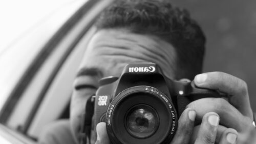 Professional Photographer Holding Canon Camera High-Resolution Desktop Wallpaper