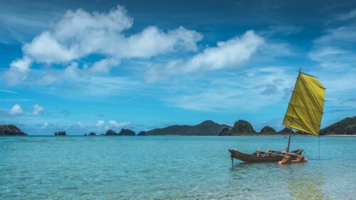 Stunning Outrigger Boat on Turquoise Tropical Waters 4K Wallpaper