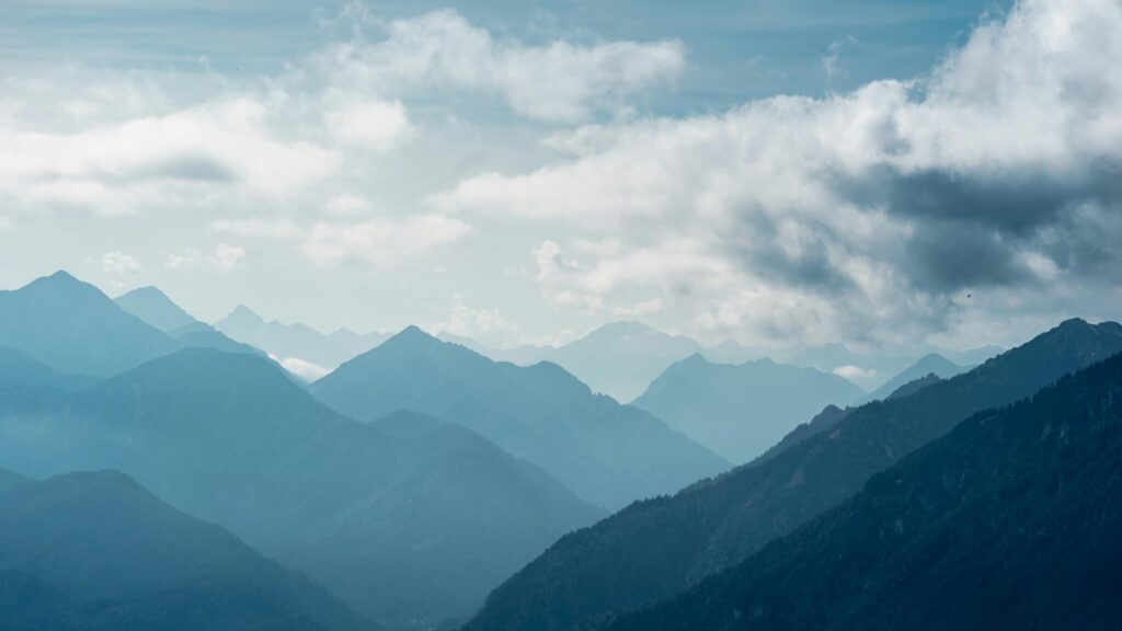 Blue Mountain Range Peaks Under Moody Clouds 4K Desktop Wallpaper