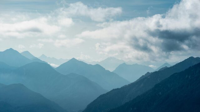 Blue Mountain Range Peaks Under Moody Clouds 4K Desktop Wallpaper