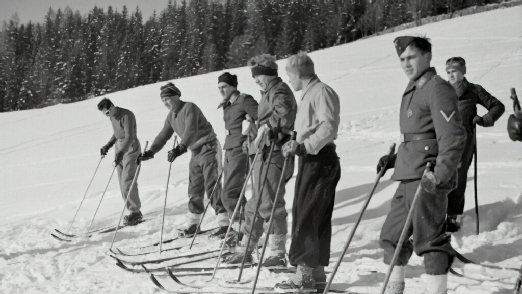Vintage Soldiers Training on Skis in Snowy Mountains Desktop Wallpaper