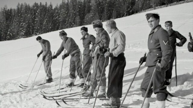 Vintage Soldiers Training on Skis in Snowy Mountains Desktop Wallpaper