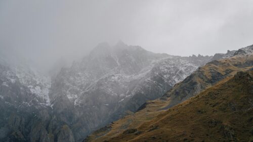 Majestic Snowy Mountain Peaks Shrouded in Mist Desktop Wallpaper