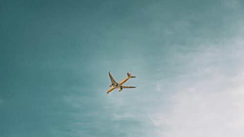 Minimalist Passenger Airplane Soaring Through Calm Blue Sky 4K Wallpaper