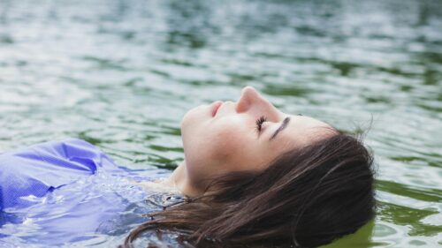 Woman Floating Relaxed in Calm Water 4K Desktop Wallpaper