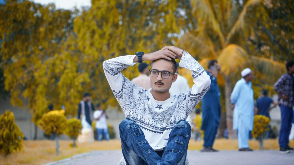 Young Man in Paisley Shirt Sitting Outdoors Desktop Wallpaper