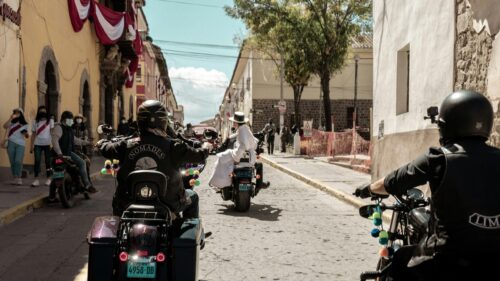 Bikers Riding Through Historic Cobblestone Streets 4K Wallpaper