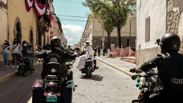 Bikers Riding Through Historic Cobblestone Streets 4K Wallpaper