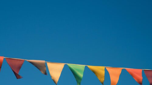 Vibrant Colorful Bunting Flags Under Clear Blue Sky 4K Wallpaper