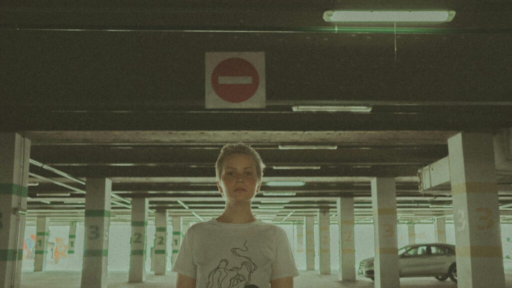 A Person Standing in a Moody Underpass Parking Garage Desktop Wallpaper