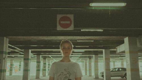 A Person Standing in a Moody Underpass Parking Garage Desktop Wallpaper