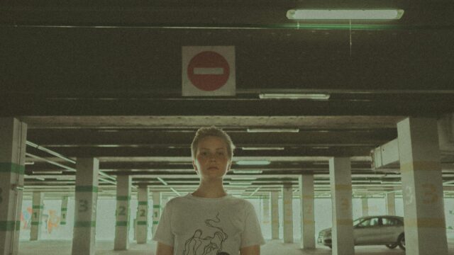 A Person Standing in a Moody Underpass Parking Garage Desktop Wallpaper