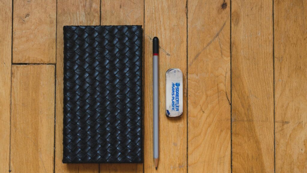 Minimalist Stationery Setup on Wooden Floor Desktop Wallpaper