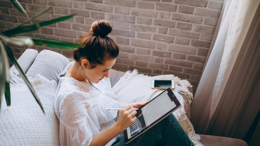 Woman Digital Artist Using Tablet on Sofa 4K Desktop Wallpaper