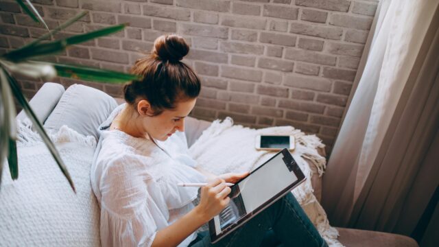 Woman Digital Artist Using Tablet on Sofa 4K Desktop Wallpaper