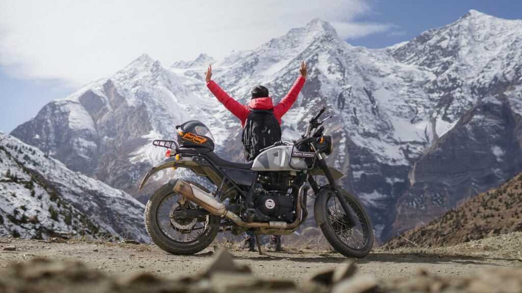 Biker Celebrating at Snow Mountain Peaks 4K Desktop Wallpaper