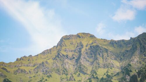Majestic Green Mountain Peak Under Clear Blue Sky 4K Wallpaper