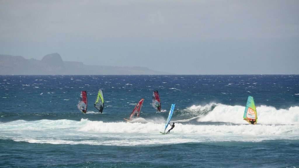 Thrilling Windsurfing Action in Choppy Ocean Waters Desktop Wallpaper