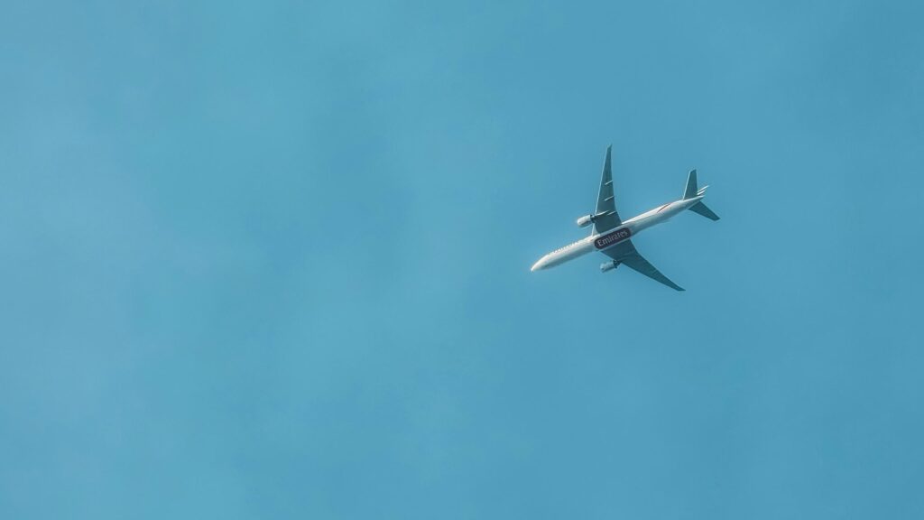 Emirates Passenger Plane Flying Through Clear Blue Sky 4K Wallpaper
