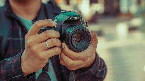 Close-up of a Photographer Holding a Canon Camera Desktop Wallpaper