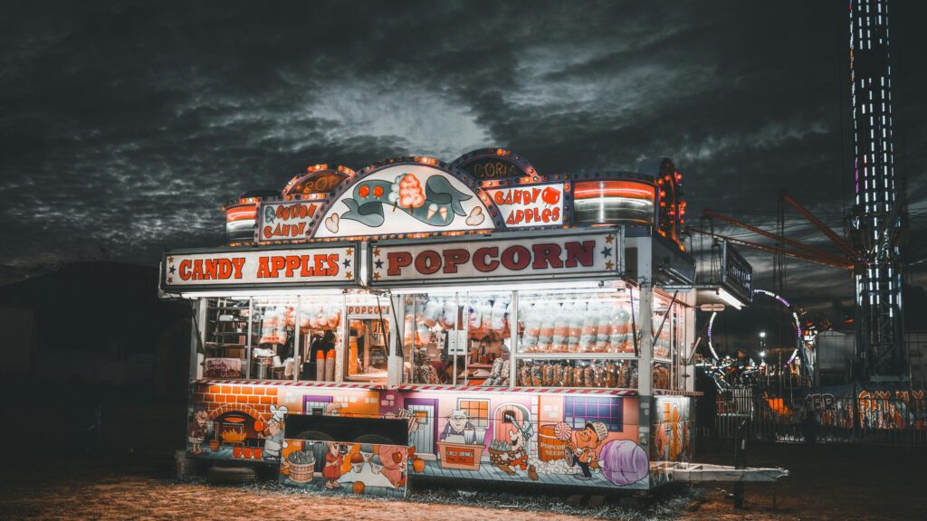 Vintage Carnival Popcorn and Candy Apple Stand at Night 4K Wallpaper