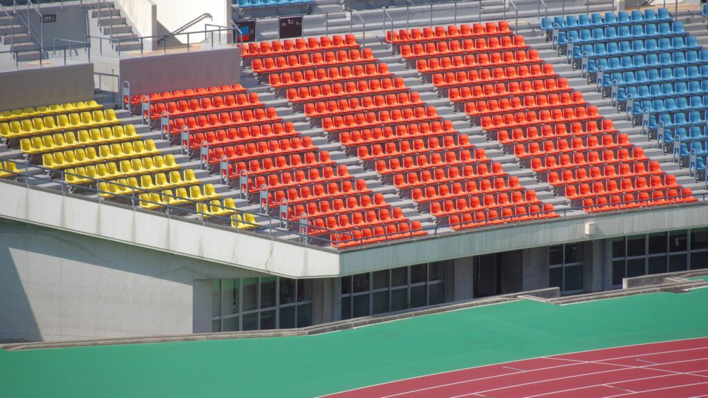 Vibrant Stadium Seating Rows with Colorful Orange and Yellow Seats Desktop Wallpaper