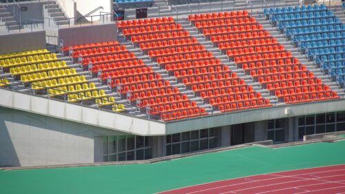 Vibrant Stadium Seating Rows with Colorful Orange and Yellow Seats Desktop Wallpaper