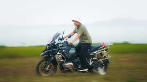 Man Riding Adventure Motorcycle on Grassy Field Desktop Wallpaper