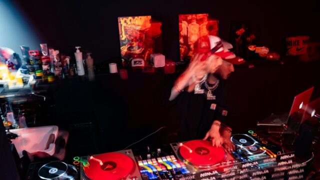 DJ Performing Live on Turntables in Red Nightclub Atmosphere 4K Wallpaper