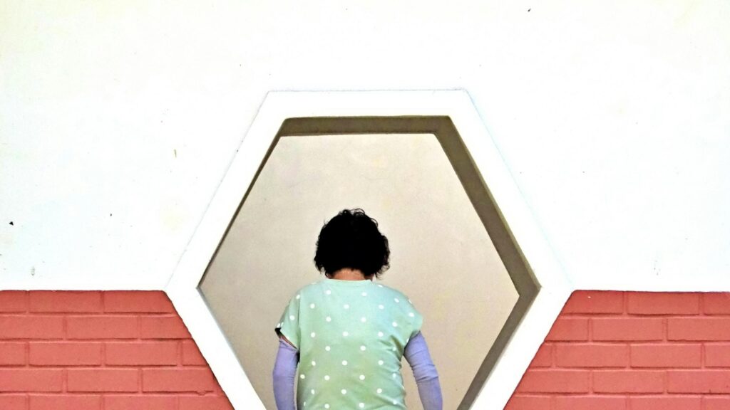Minimalist Woman in Polka Dot Shirt Framed by Hexagon Window Desktop Wallpaper