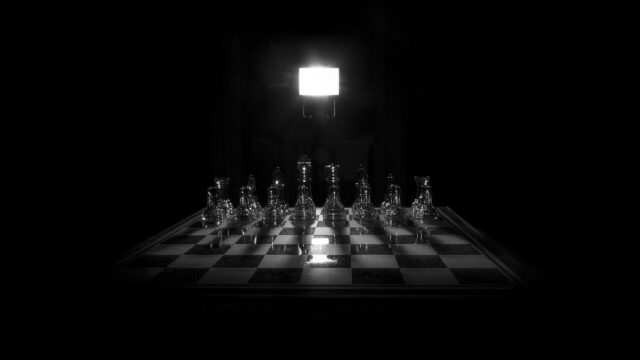 Dramatic Glass Chess Set Under Spotlight 4K Desktop Wallpaper