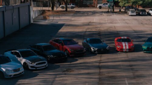Luxury Sports Cars Lineup in Sunset Parking Lot Desktop Wallpaper