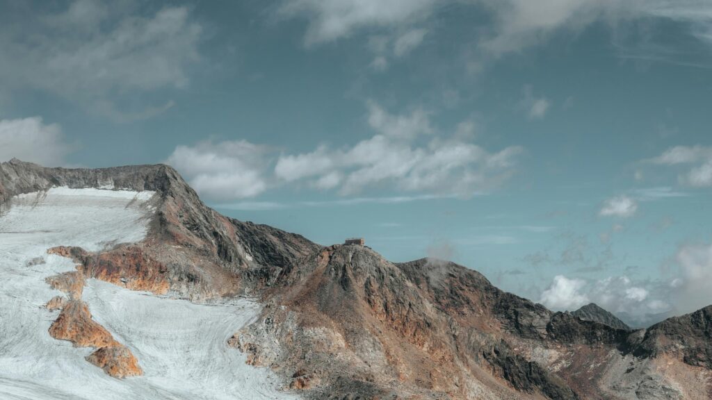Mountain Hut on Alpine Glacier Ridge 4K Wallpaper