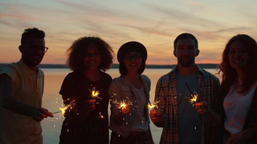 Friends Holding Sparklers at Sunset Beach Party 4K Wallpaper