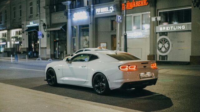 White Chevrolet Camaro Sportscar on City Street at Night 4K Wallpaper